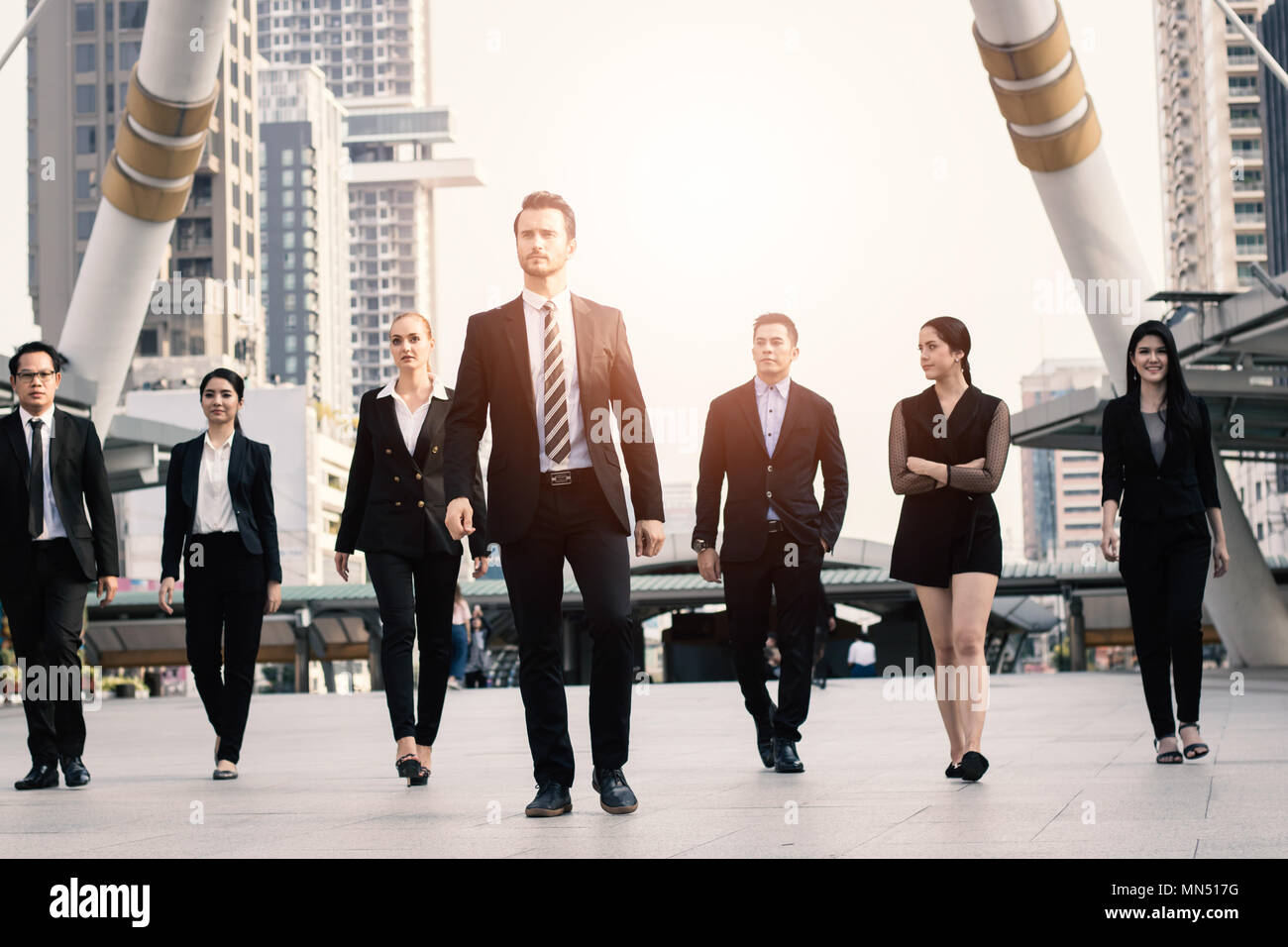 Teamwork and professional partnership concept, businesspeople team of multi ethnic walking with confidence in full suit Stock Photo
