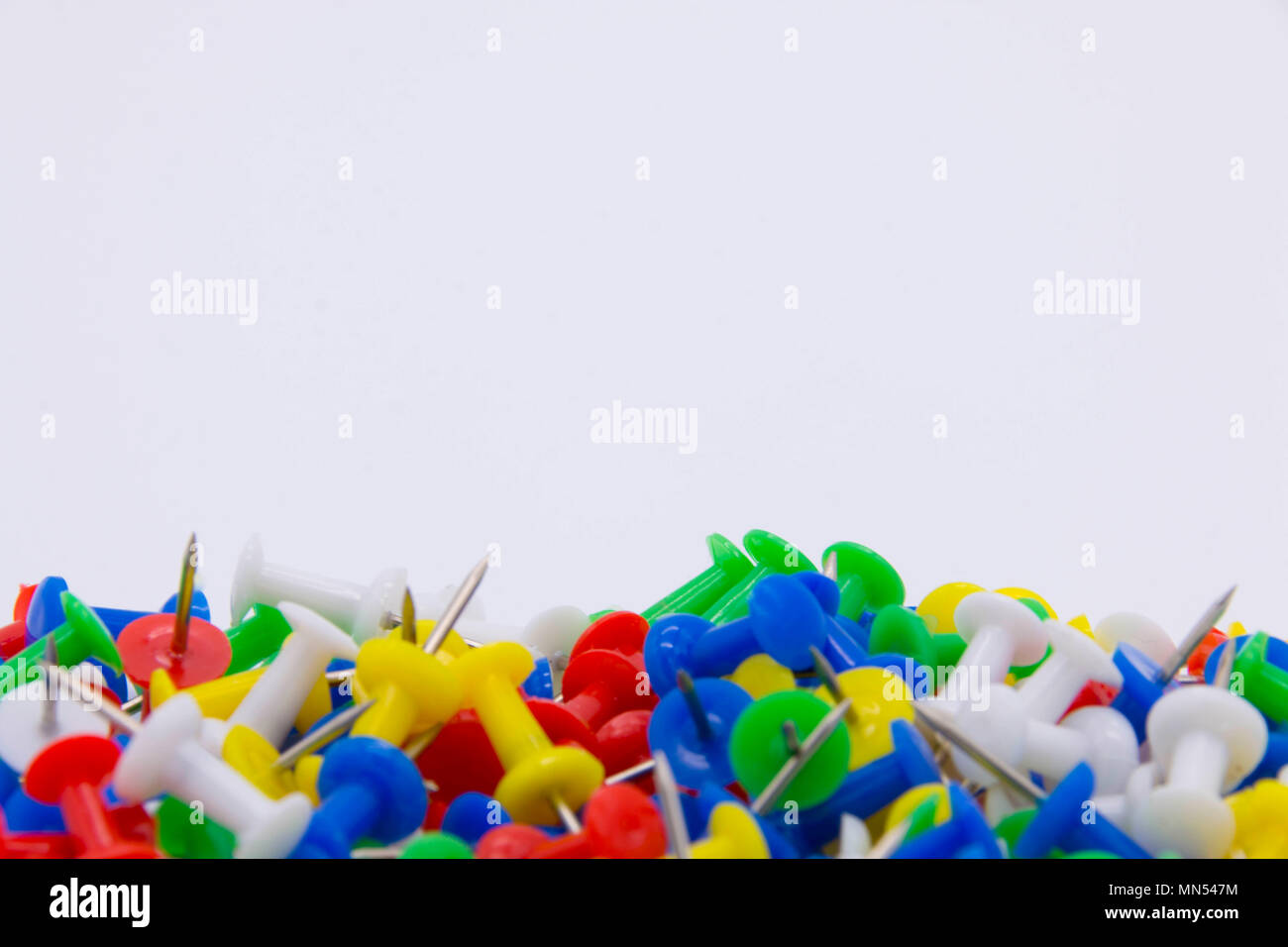 Pile of plastic notice board push pins on a white background Stock