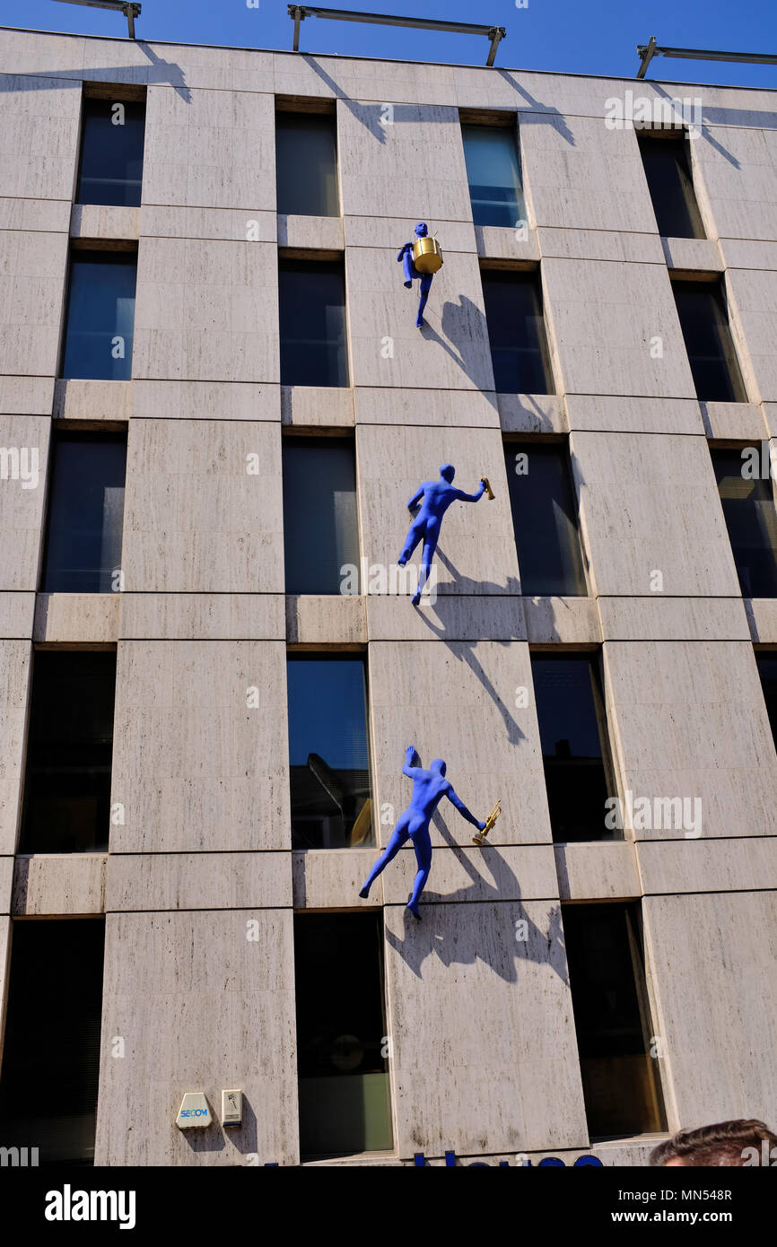 Walls and Trumpets by Ofra Zimbalista Sculptures of blue-clad men carrying musical instruments hang from the Maya House building in Borough High Street Stock Photo