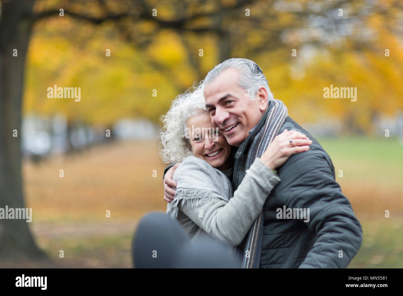 Happy senior couple hugging in autumn park Stock Photo