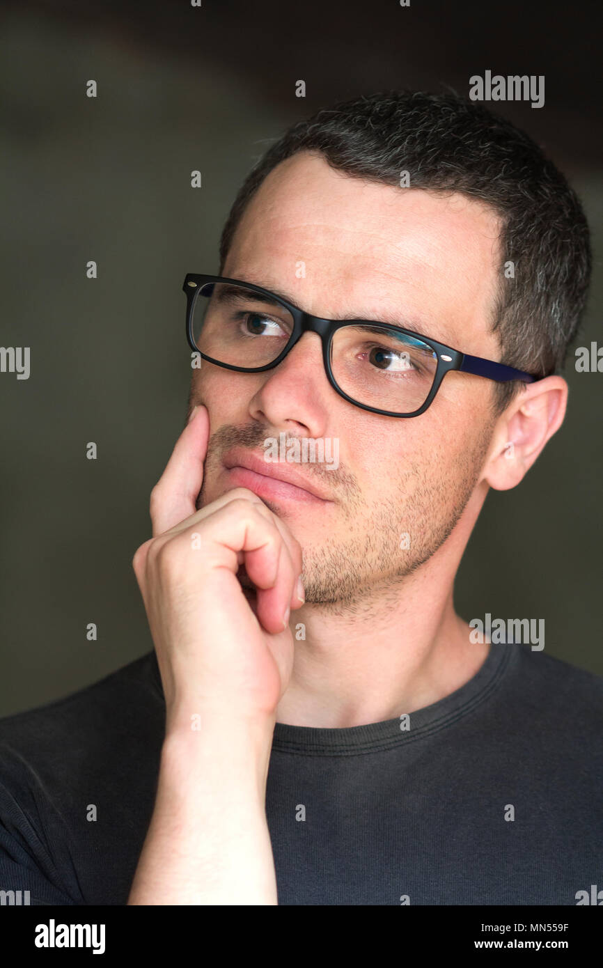 Portrait of young handsome serious black-haired unshaven confident ...