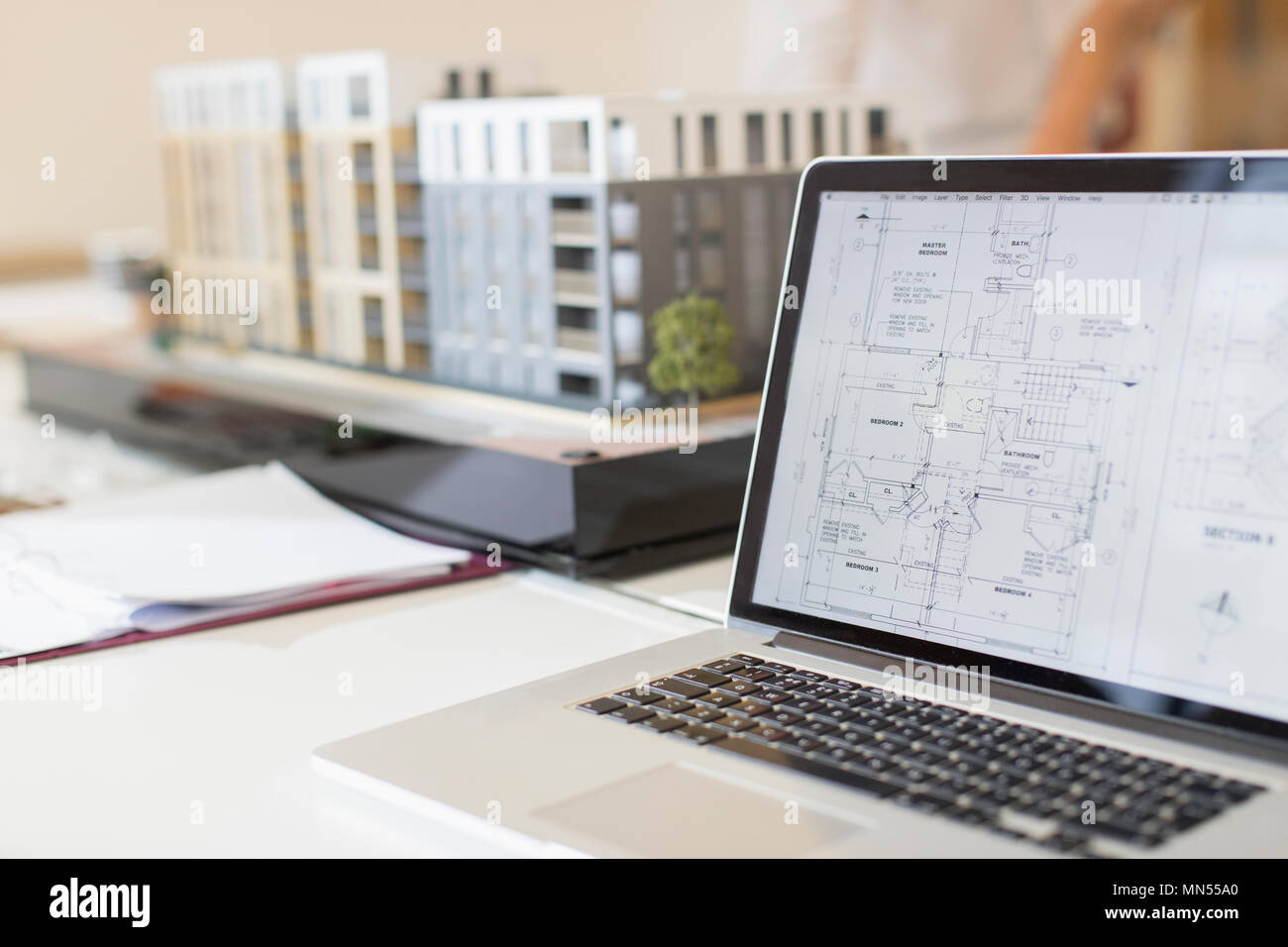Digital blueprint on laptop next to model Stock Photo
