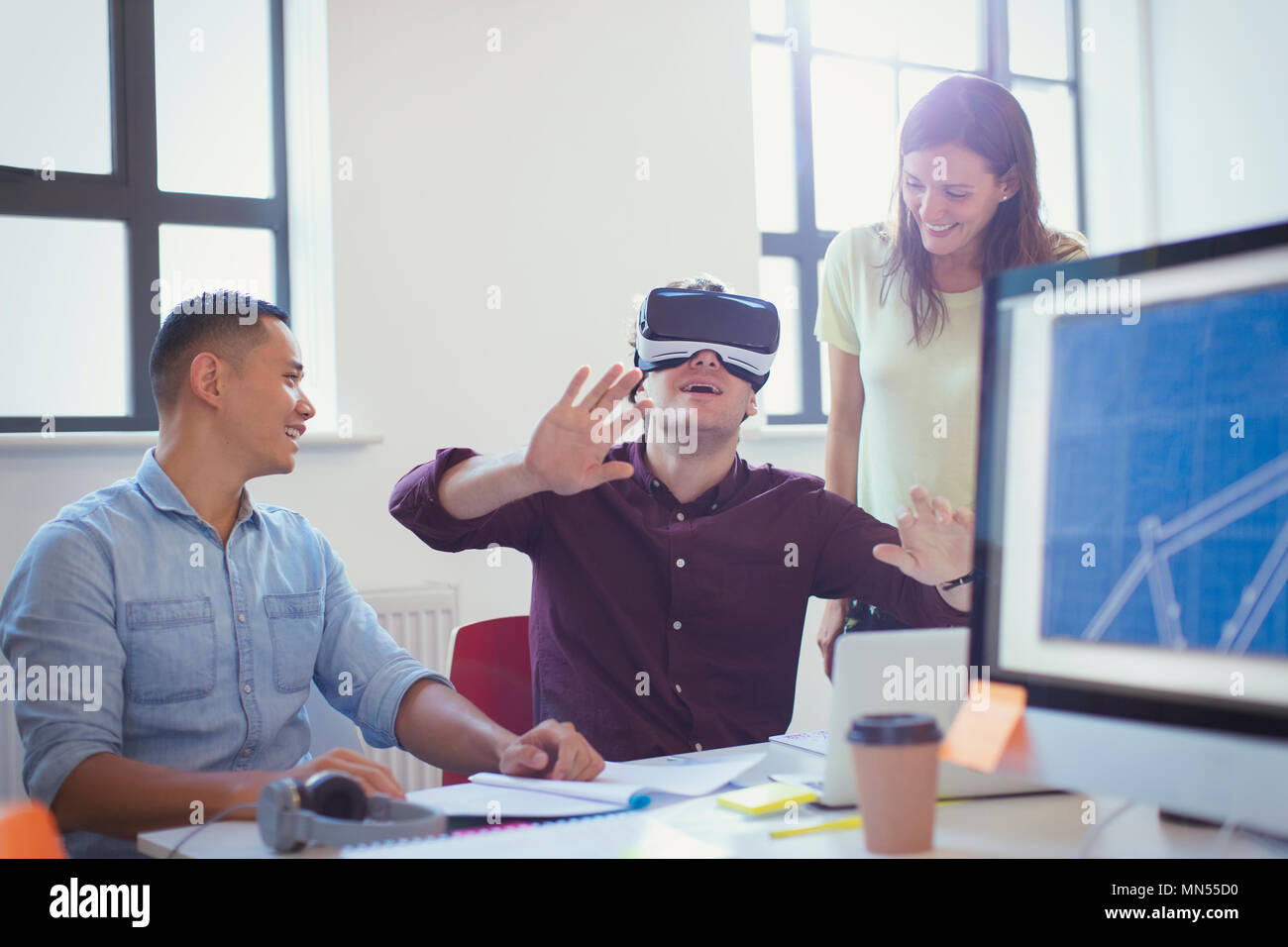 Computer programmers testing virtual reality simulator glasses in office Stock Photo