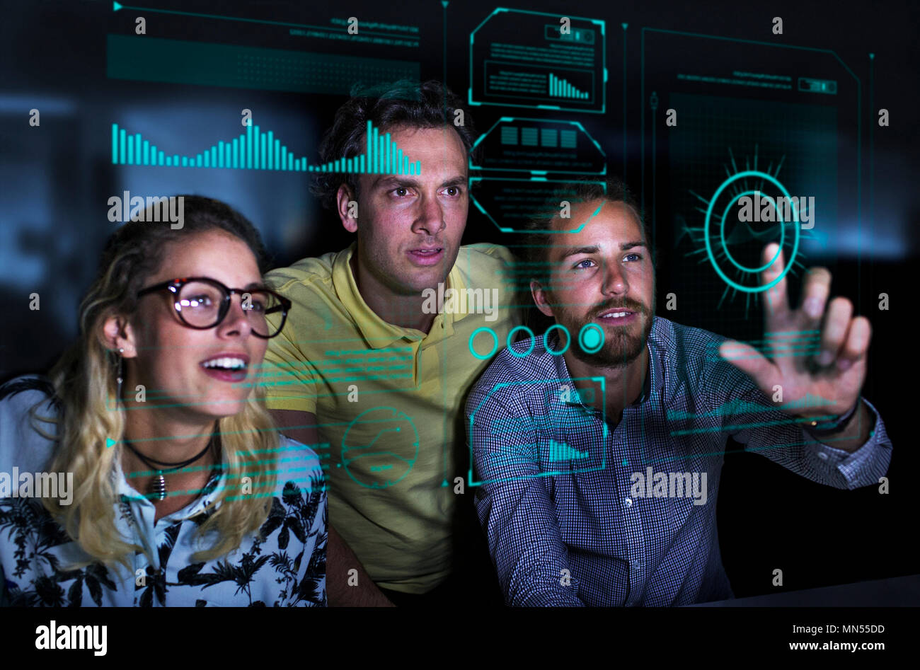 Designers viewing data on futuristic hologram screen Stock Photo