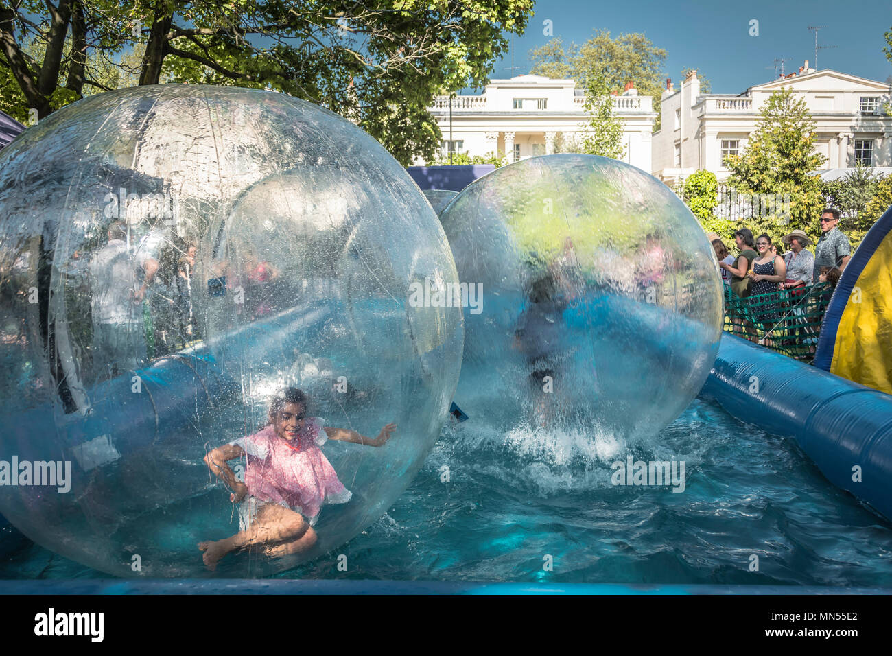 Children enjoy fairground attraction water walkers on a Bank Holiday Monday Stock Photo