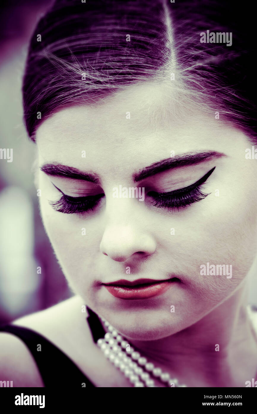 young woman with downcast closed eyes,long false eye lashes Stock Photo