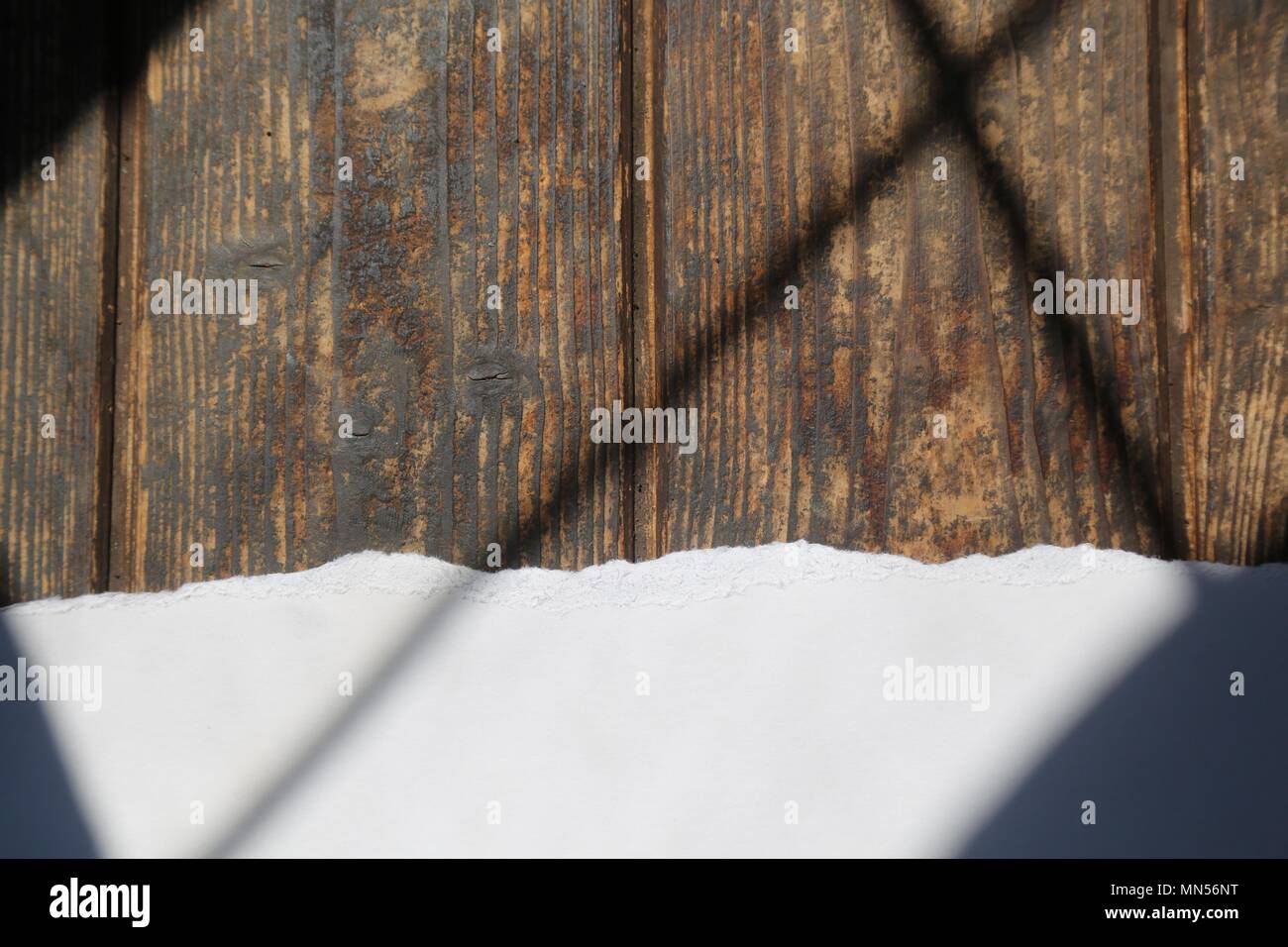 Torn White Paper on Dark Wood Background with shaft of light Stock Photo