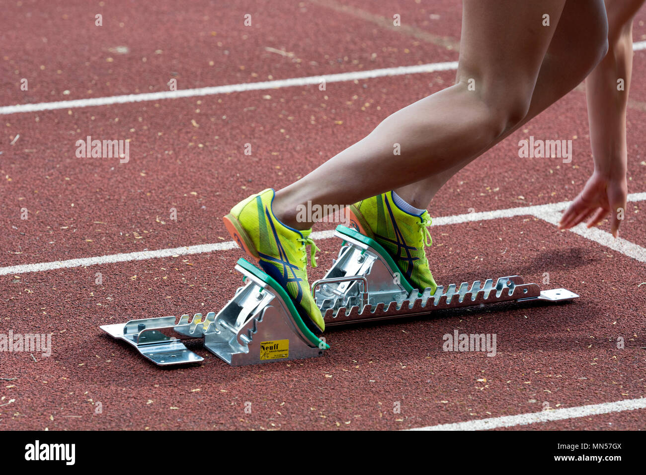 Teenage girl using blocks at start of a race, Warwickshire County Athletics Championships, Nuneaton, UK Stock Photo