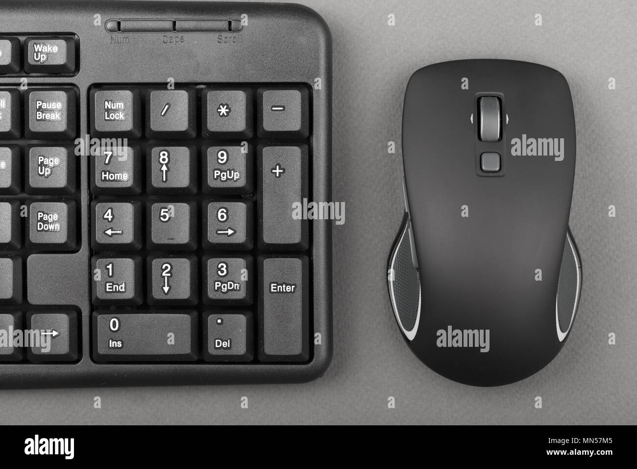 black computer mouse near the keyboard, office equipment on the table