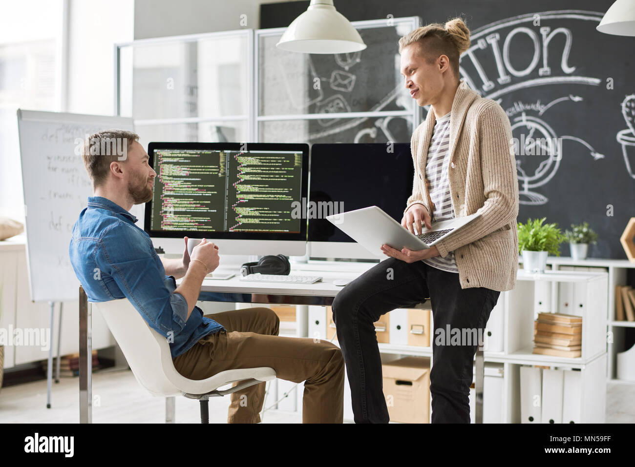 Portrait of two contemporary web developers writing code for program collaborating on startup project in modern office, copy space Stock Photo