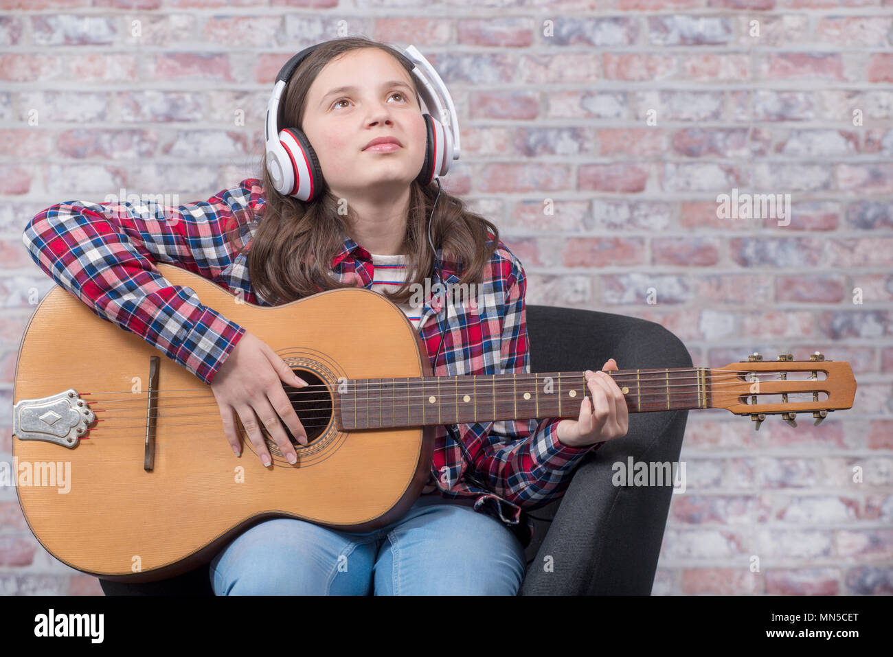 a smiling teenager girl playing an acoustic guitar Stock Photo - Alamy