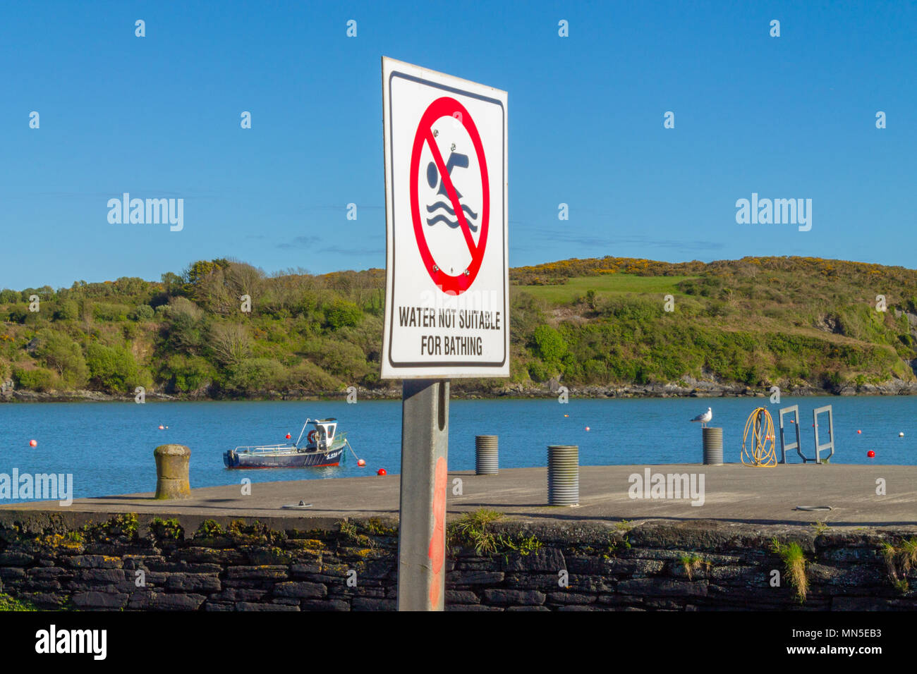 No Bathing sign warning people to stay out of what looks to be clean water due to sewage contamination from untreated outfalls Stock Photo