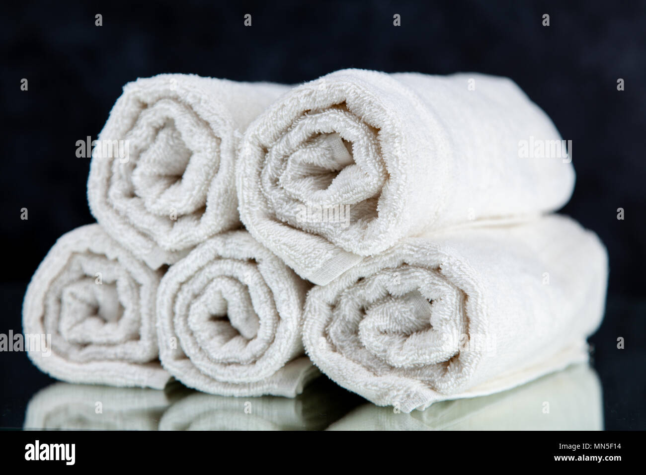 Stack of colorful clean towels on grey background. Ironing clothes on  ironing board. Stack of clean towels on table. Colored towels. Space for  text. Hygiene, fabric, laundry,spa and textile concept. Stock Photo