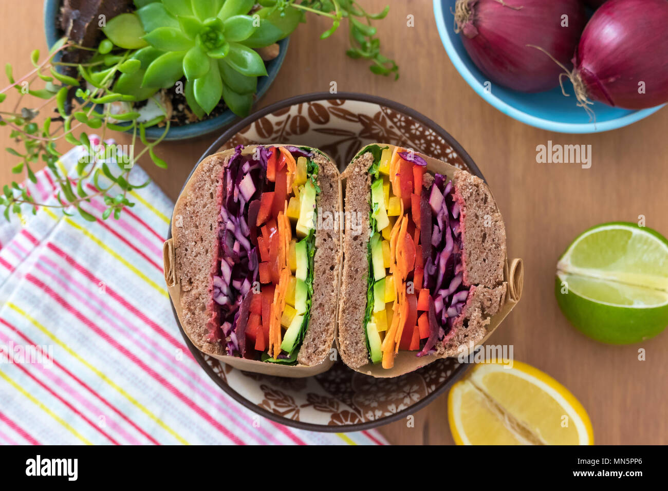 Rainbow salad sandwiches with homemade buckwheat bread, displayed on a wooden board. This fresh healthy lunch is low calorie, dairy free & gluten free. Stock Photo