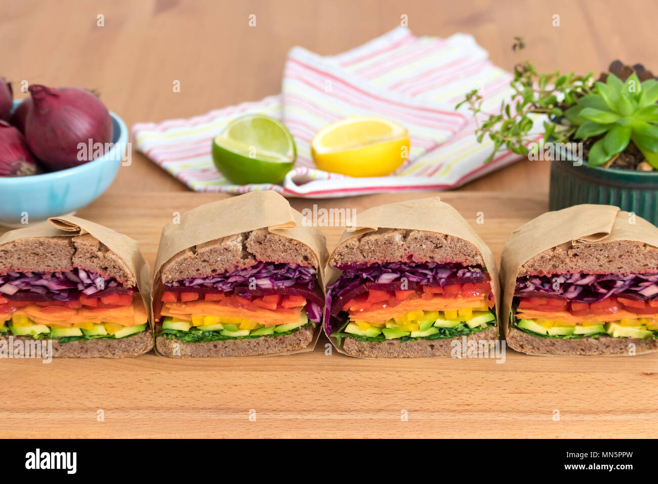 Rainbow salad sandwiches with homemade buckwheat bread, displayed on a wooden board. This fresh