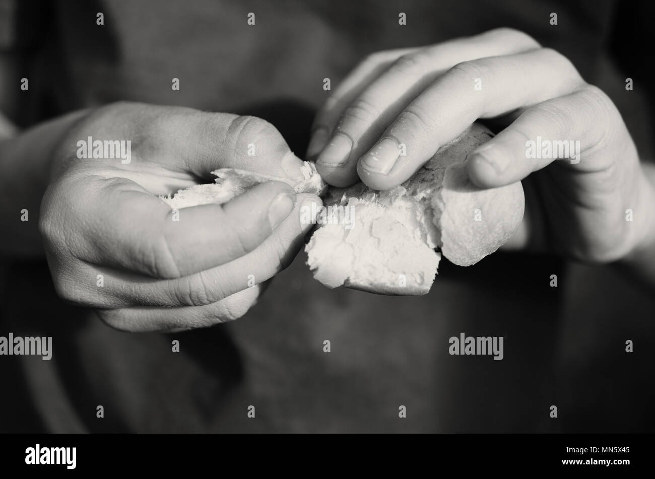 The hands of a beggar hungry boy hold and break a piece of bread Stock ...