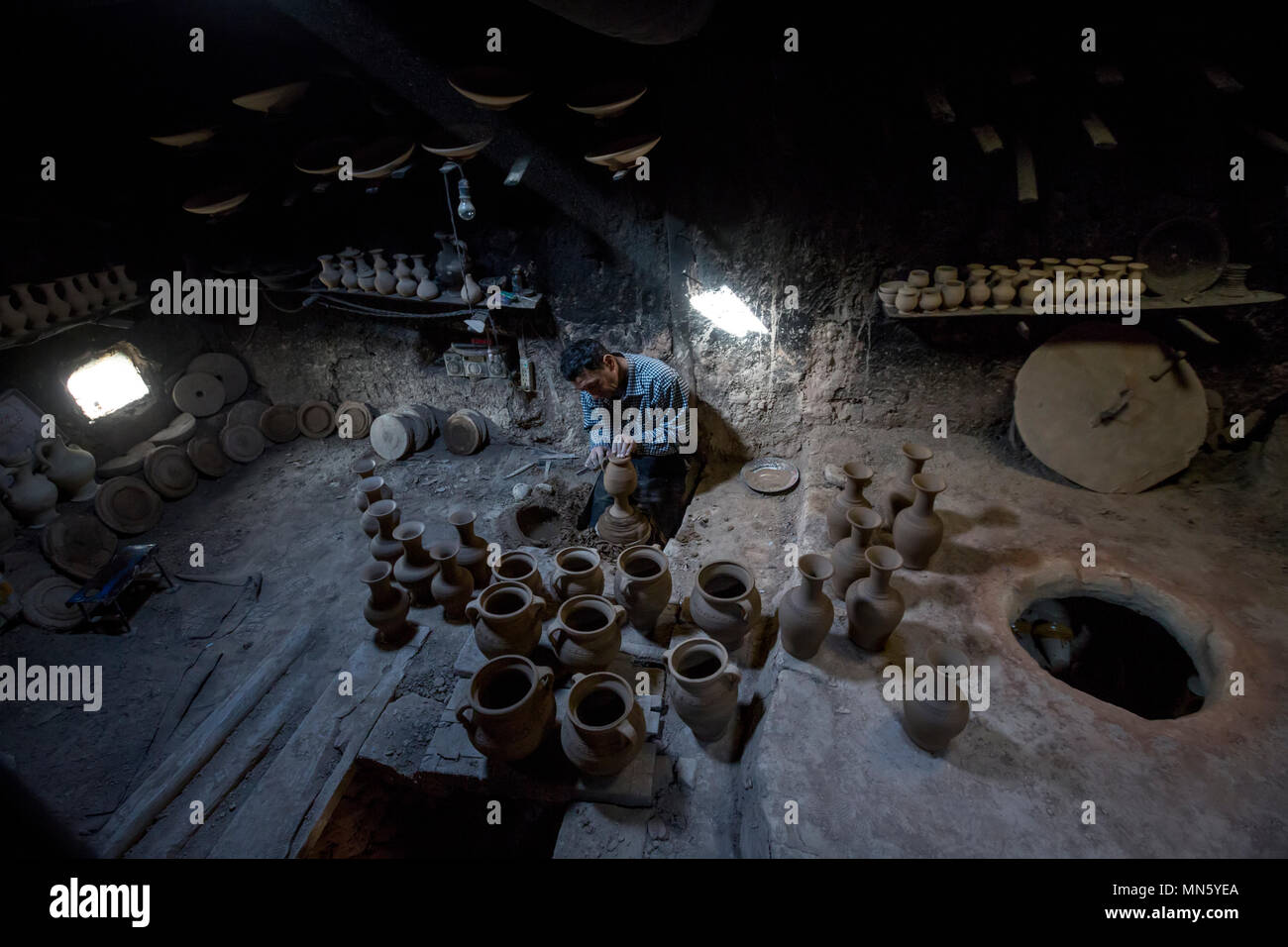 A master of the pottery creates a jug by hand on pottery wheel in Old