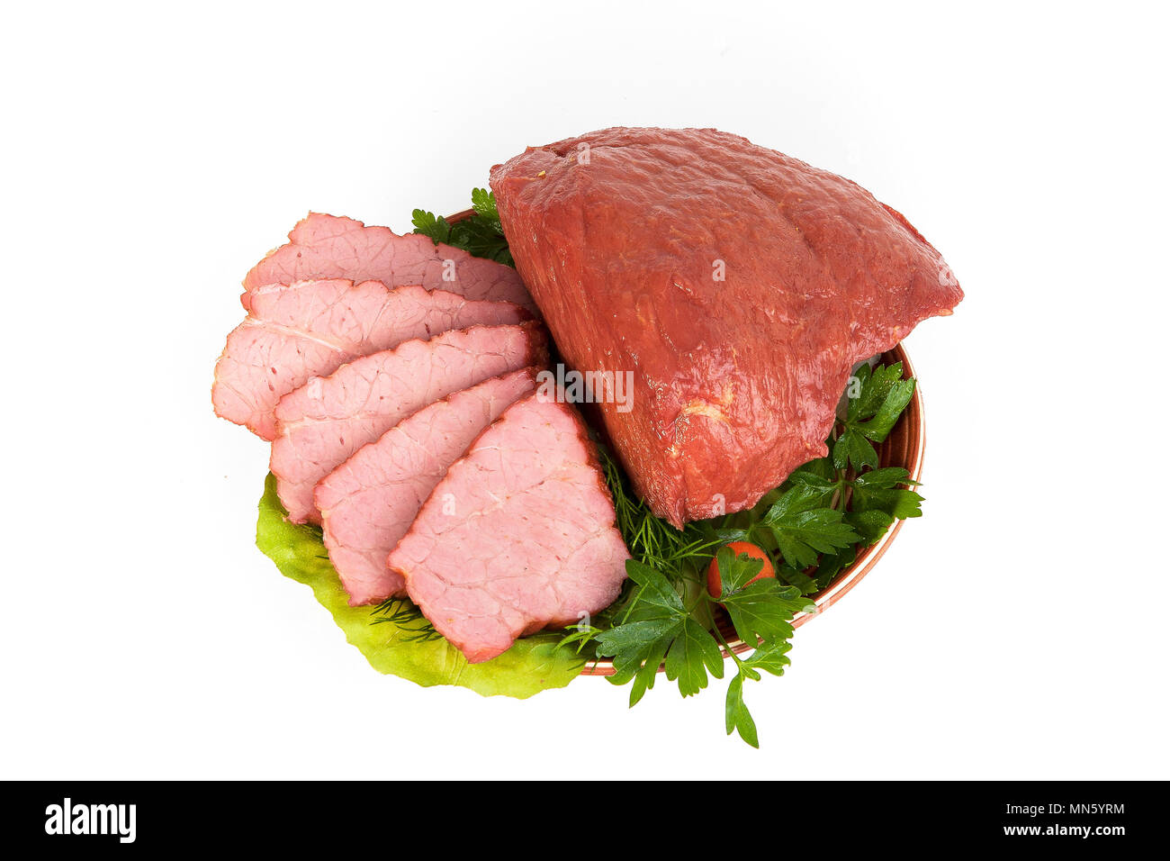 A piece of smoked meat on a clay plate with fresh seasonings with slices. Good snack for beer. Sliced morning sandwich. An excellent dish for breakfas Stock Photo