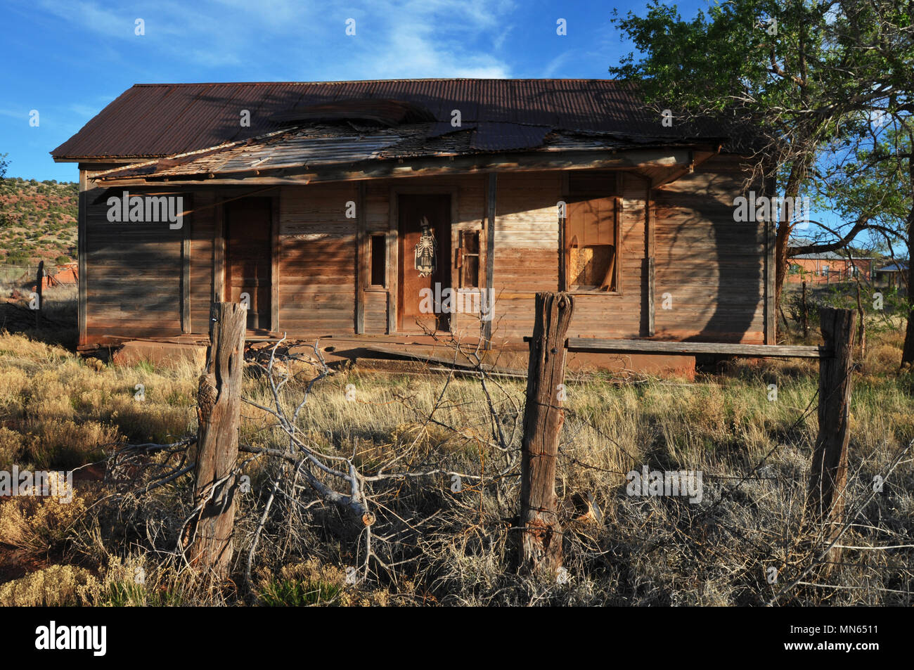 The remnants of a fence stand in front of an abandoned house in the Route 66 town of Cuervo, New Mexico. Stock Photo
