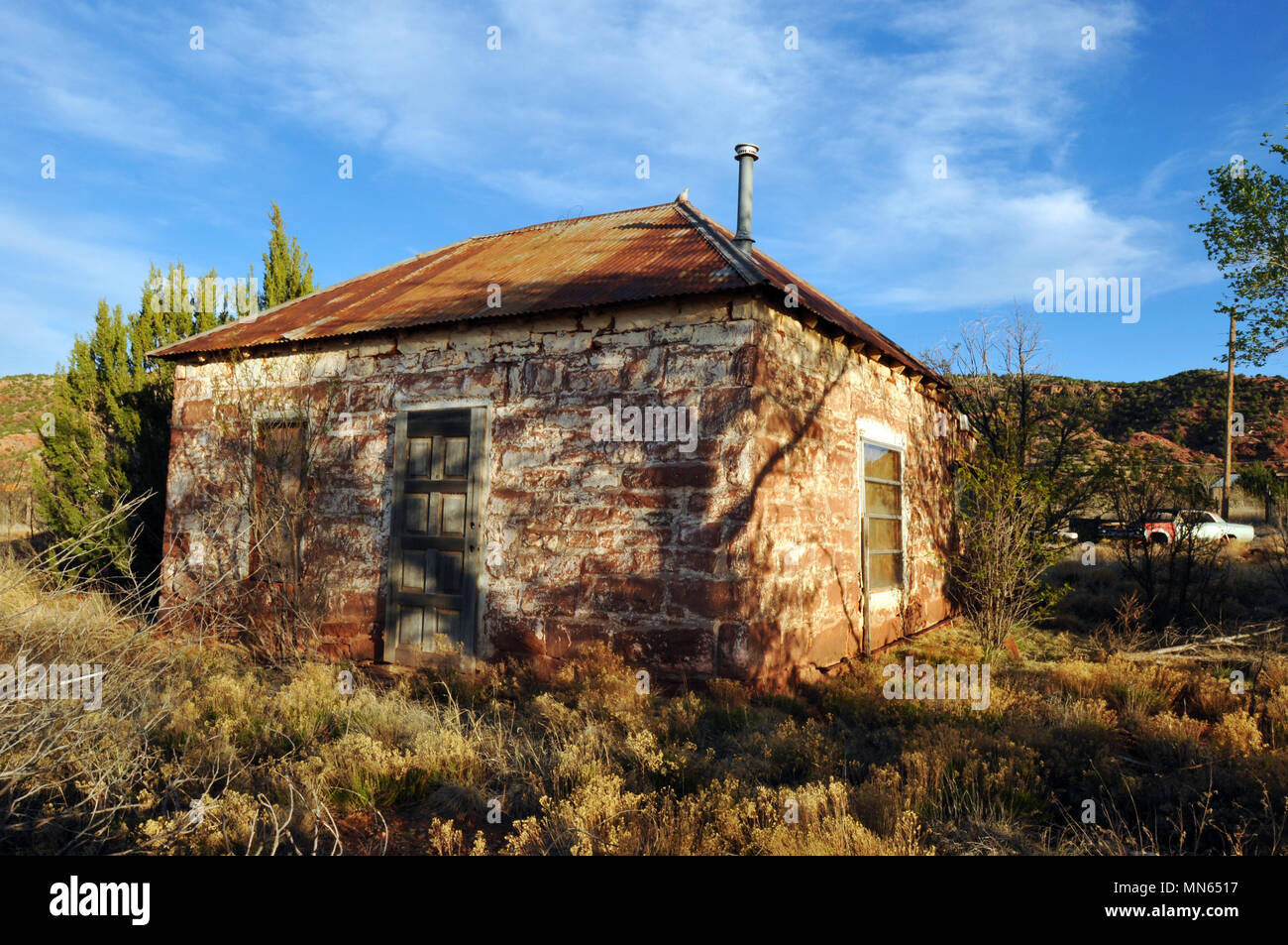 Late afternoon shadows fall across an abandoned stone house in the Route 66 town of Cuervo, New Mexico. Stock Photo
