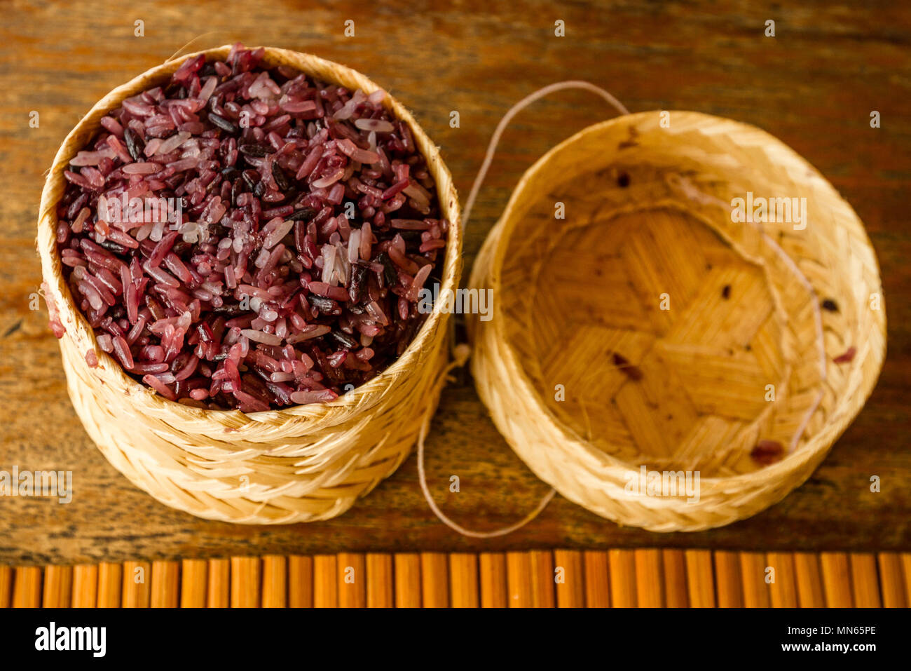 Purple sticky rice in a traditional serving basket, Laos Stock Photo