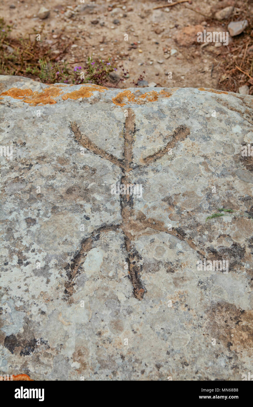 Ancient sign on stone at excavations in Phaistos in Crete. Meaning unknown so far to archaeologists at the site Stock Photo
