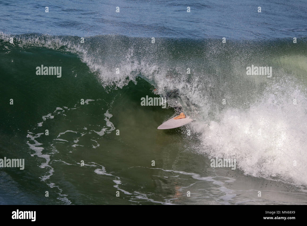 surfer coming out of the barrel of a wave Stock Photo