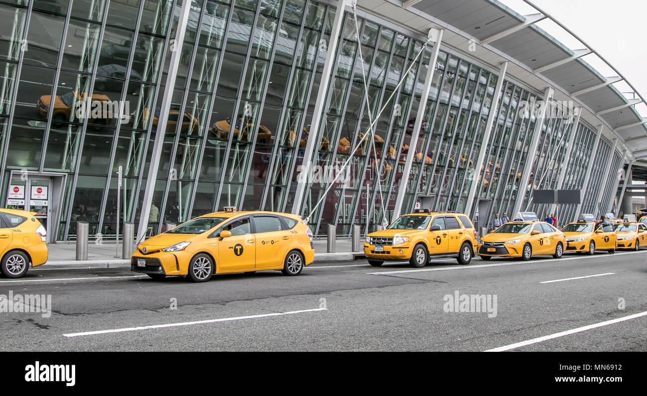 Yellow taxi cabs have formed a line in front of JFK airport's terminal 4. Stock Photo