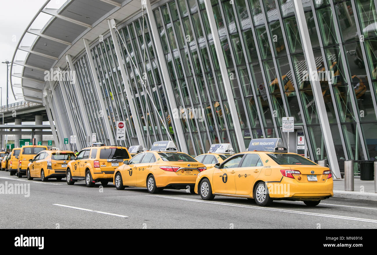 Yellow taxi cabs have formed a line in front of JFK airport's terminal 4. Stock Photo