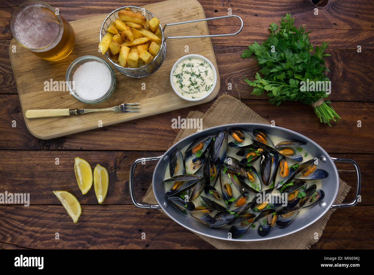 Mussels cooked in a white wine sauce with chunky chips and dill mayonnaise Stock Photo