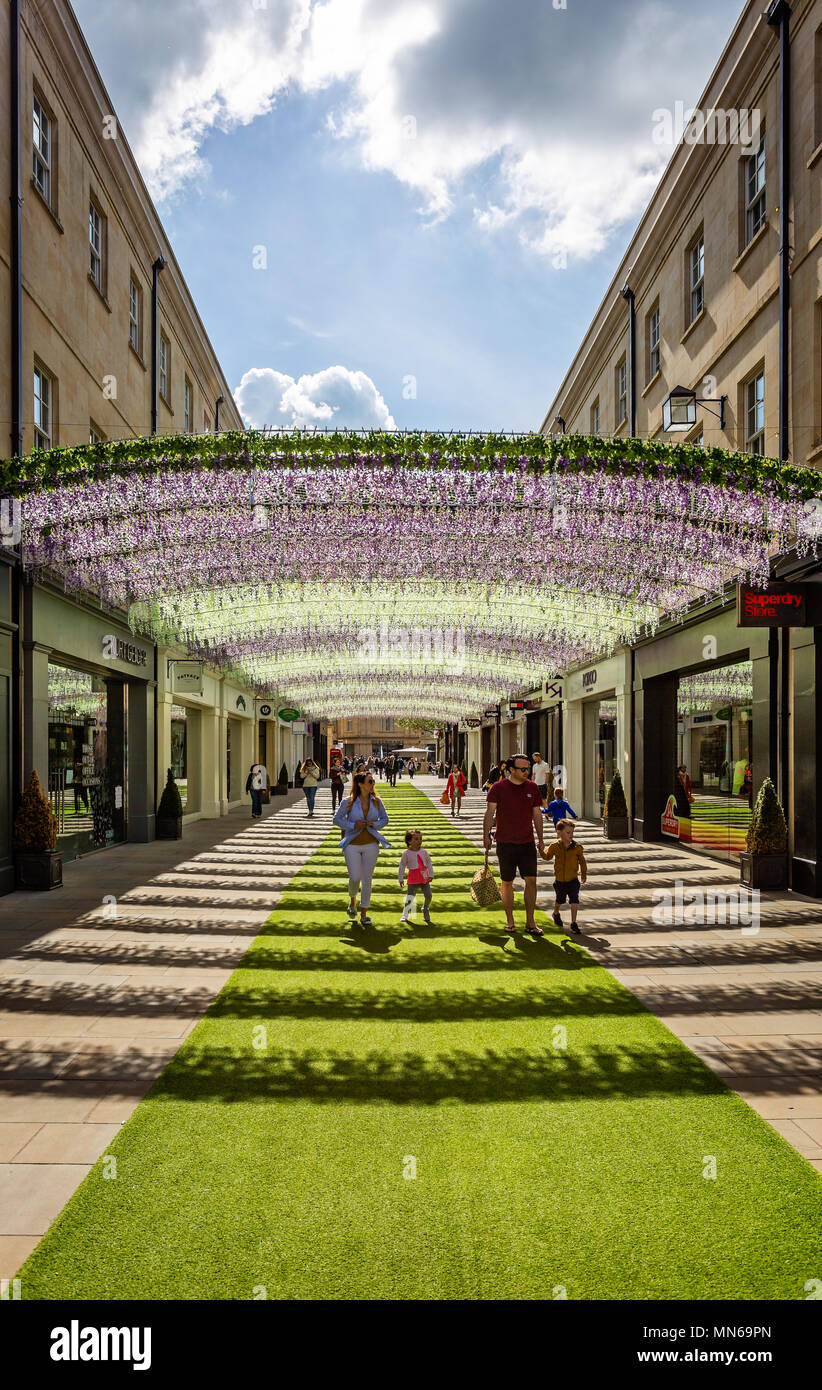 Mass of colourful flowers forming arch in Southgate Street shopping centre taken in Bath