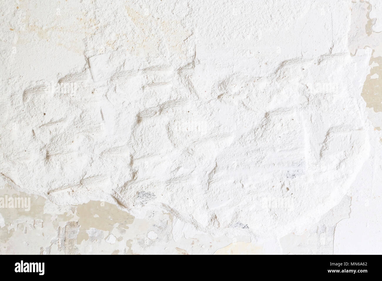 Textured ragged white wall plaster, after taking out tile. The wall ...