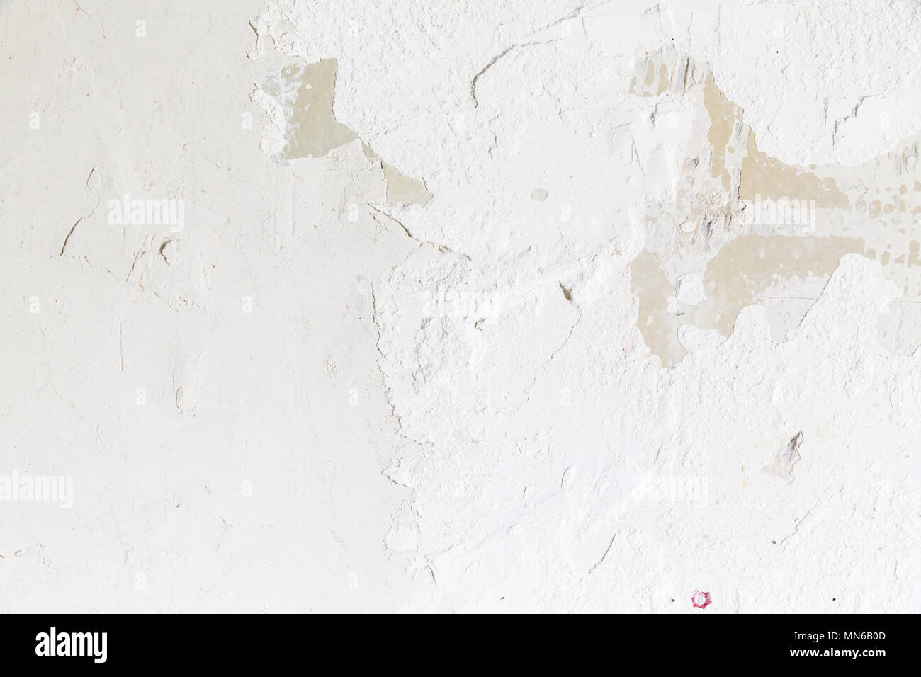 Textured ragged white wall plaster, after taking out tile. The wall ...