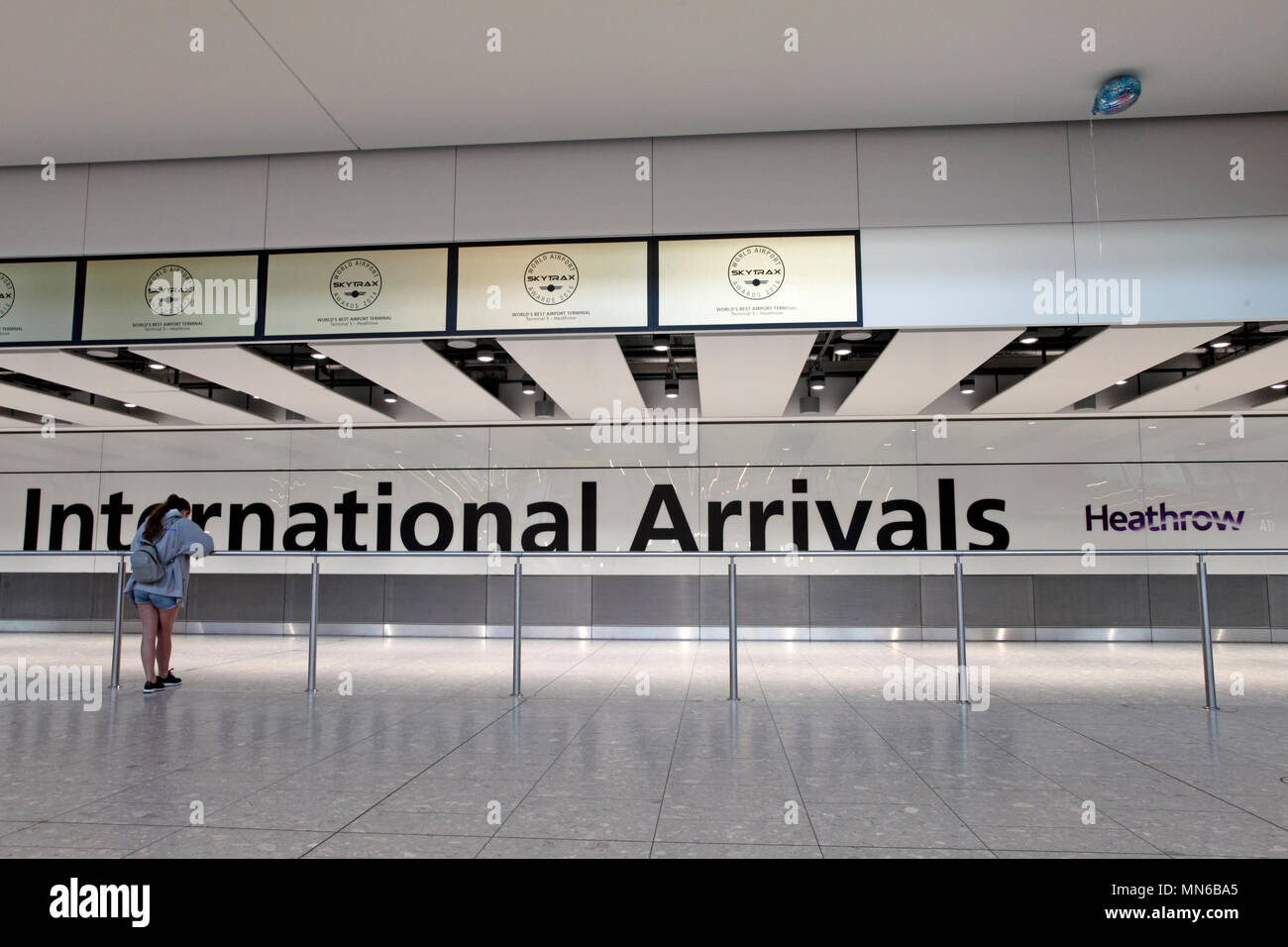 skytrax. Terminal 5. Heathrow arrivals lounge, one person waiting. Stock Photo