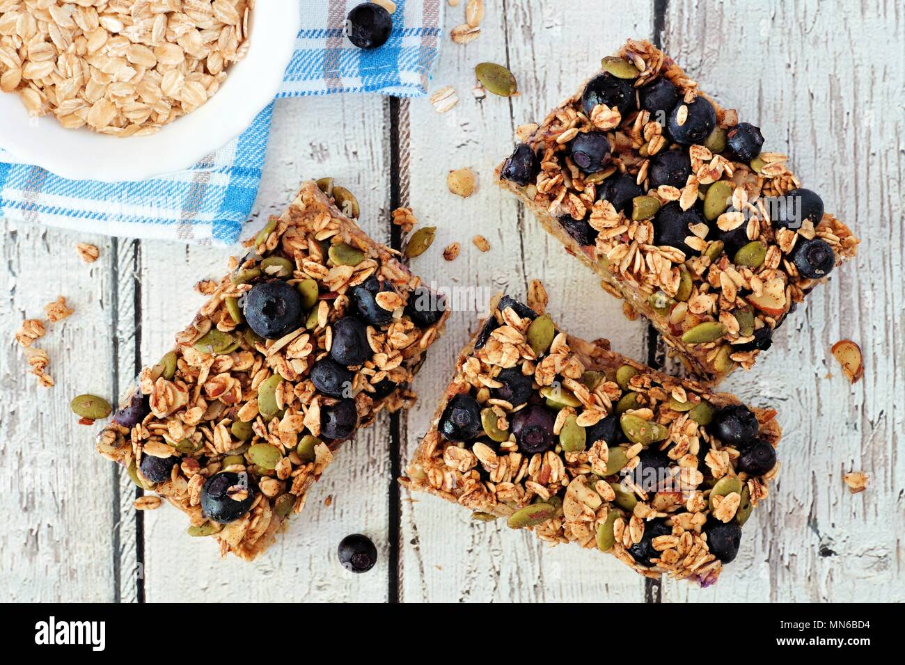 Superfood breakfast bars with oats and blueberries, overhead on white wood background Stock Photo