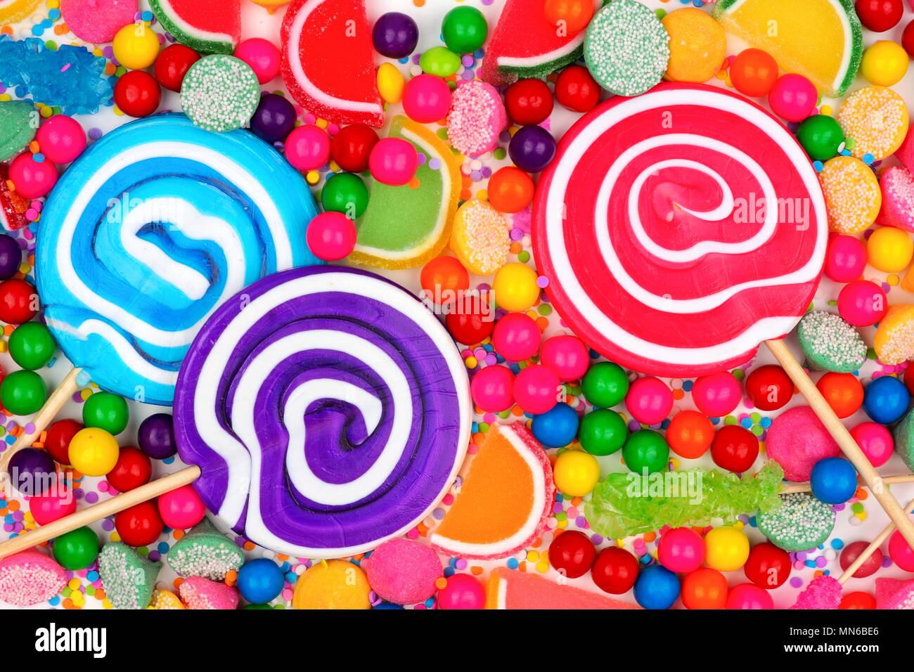 Background of colorful assorted candies including lollipops, gum balls, and jelly candies Stock Photo