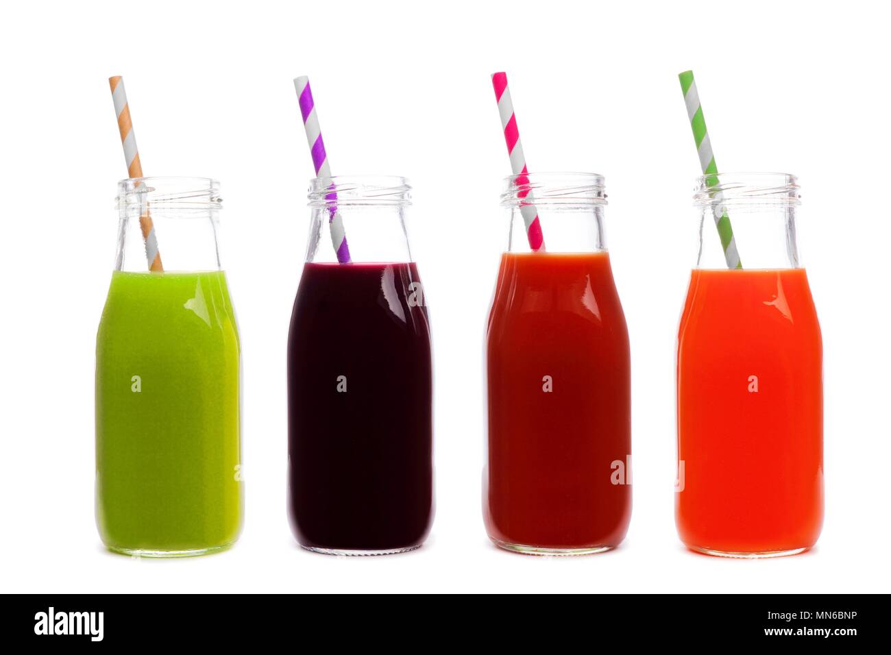 Four bottles of vegetable juice, greens, beet, tomato, and carrot, isolated on a white background Stock Photo