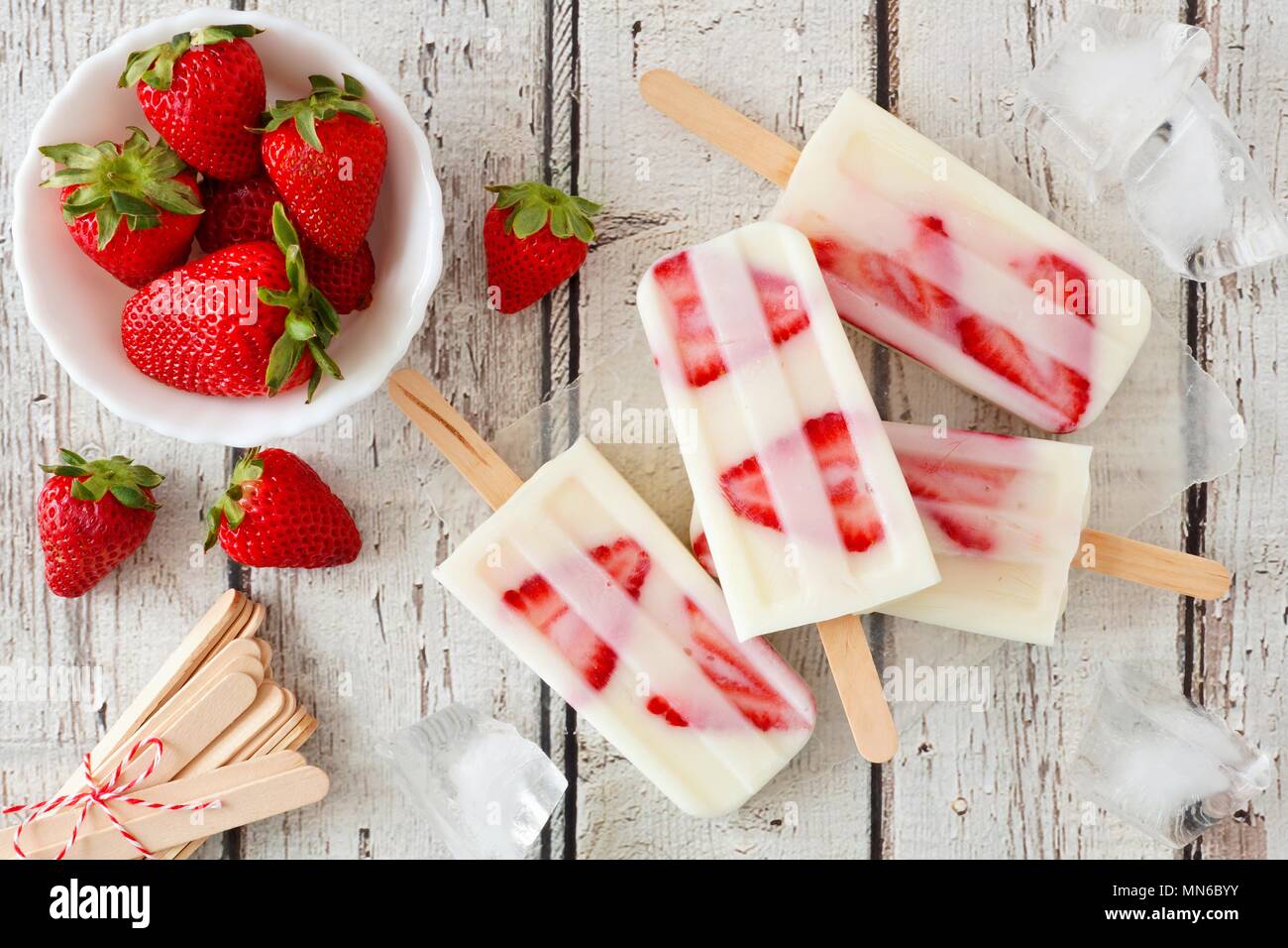 Group of homemade strawberry vanilla popsicles on a rustic white wood background Stock Photo