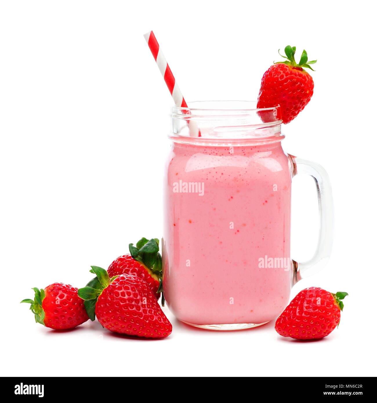 Pink strawberry smoothie in a mason jar glass with straw and scattered berries isolated on white Stock Photo