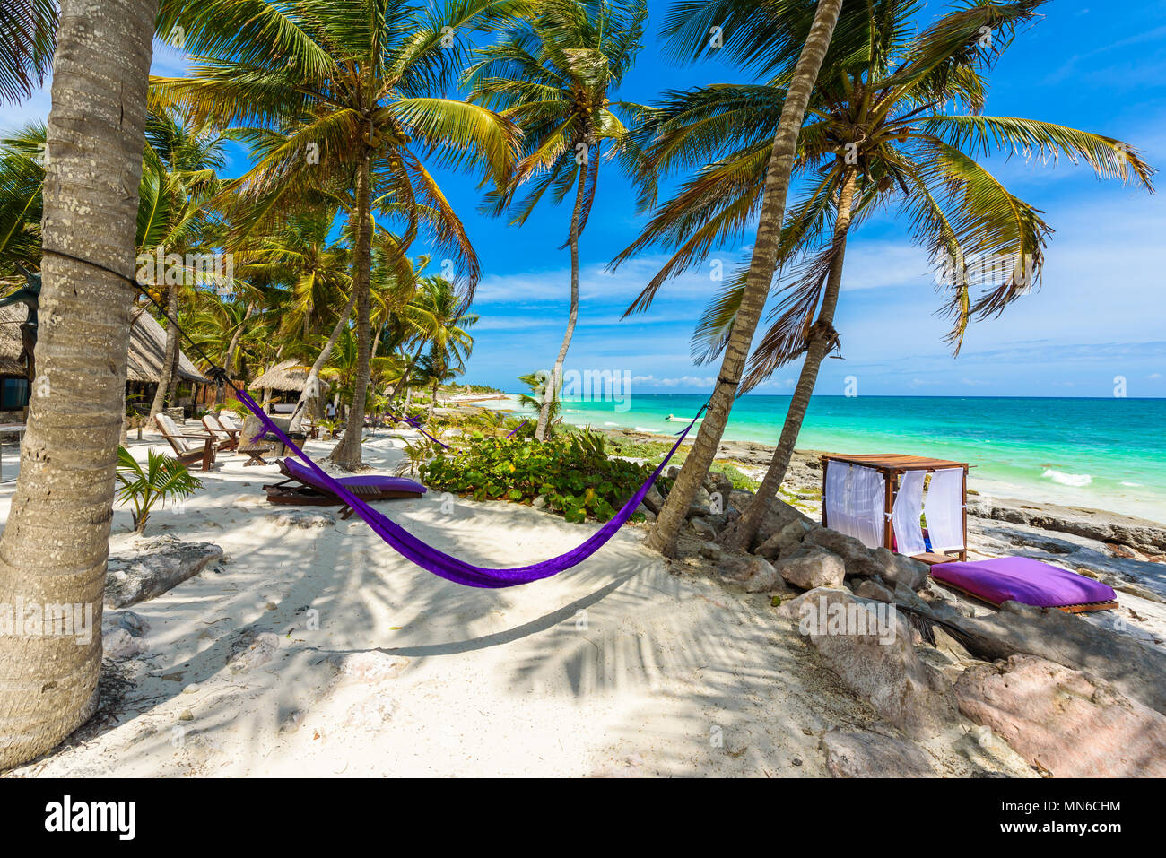 Beach beds and Hammock under the palm trees on paradise beach at