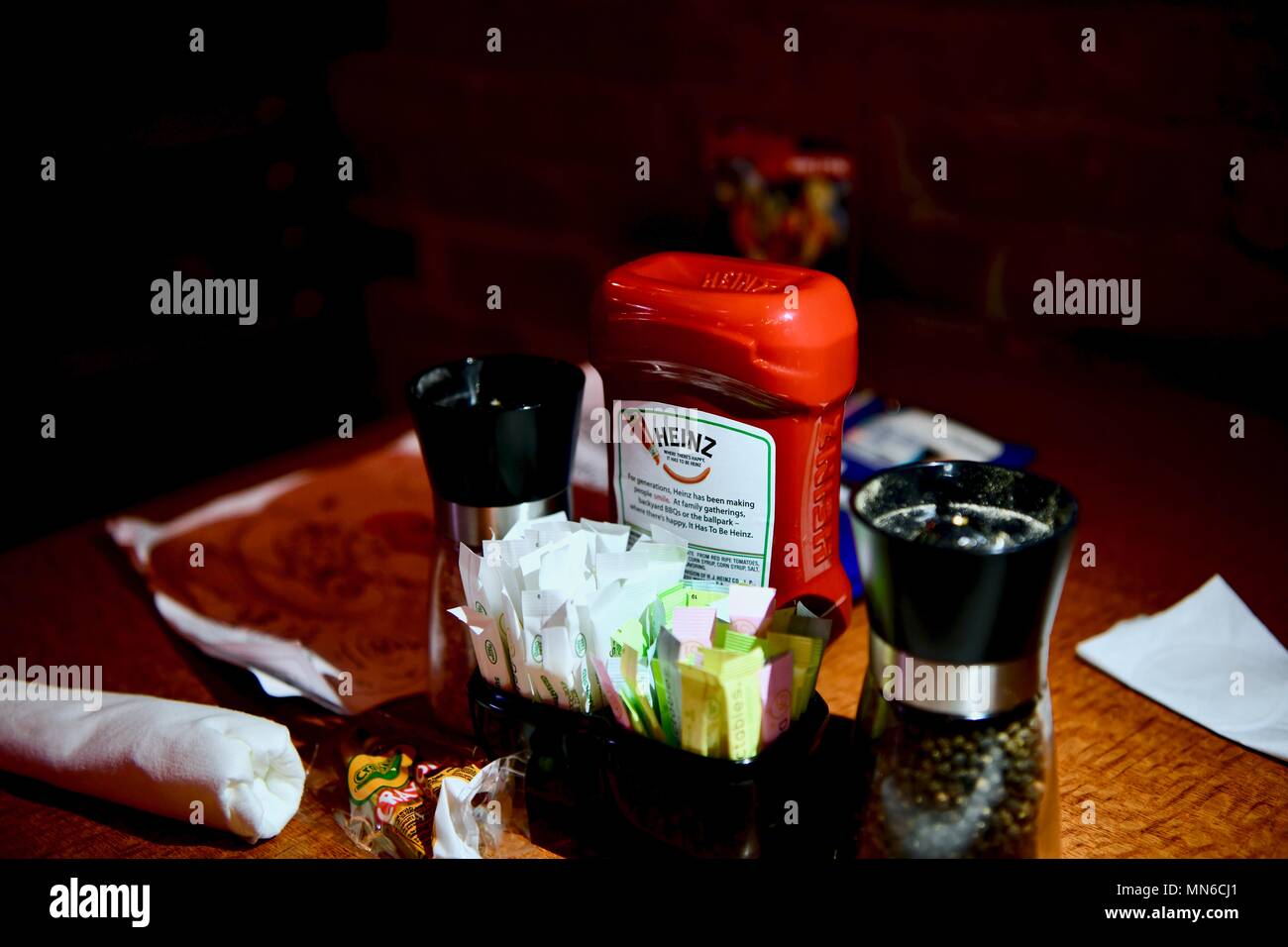 Restaurant table with ketchup, salt, pepper, and sugar Stock Photo