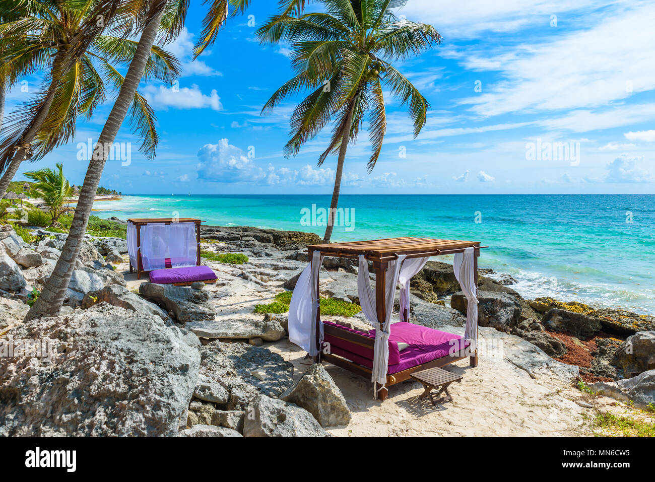 Beach beds under the palm trees on paradise beach at tropical Resort