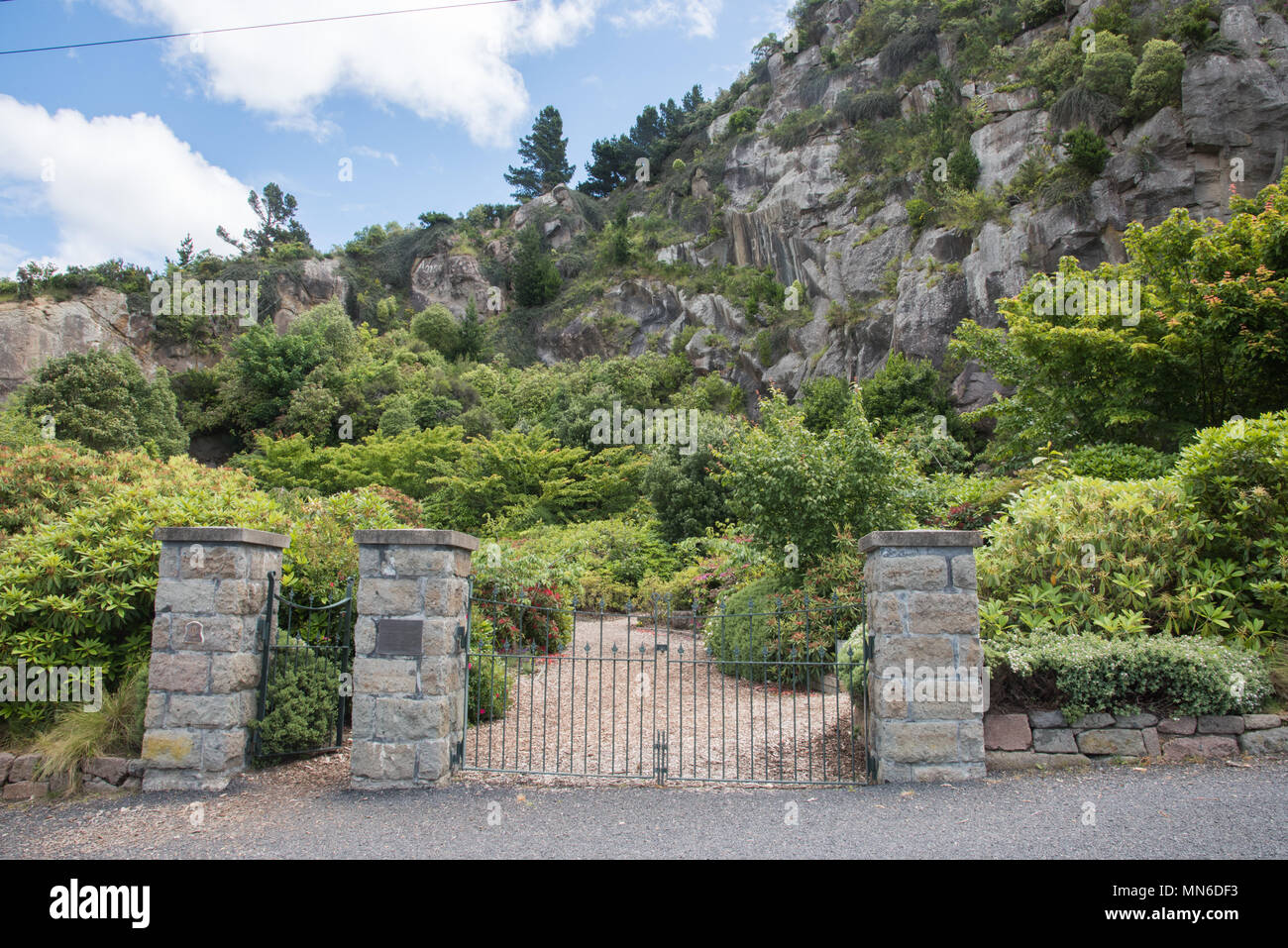 Entrance to the free public Lady Thorn Rhododendron Dell garden with lush greenery and natural rock in Port Chalmers, Dunedin, New Zealand Stock Photo
