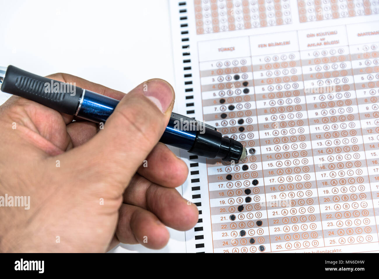 Man hand Erasing answer with pencil on Test score sheet with answers. Stock Photo