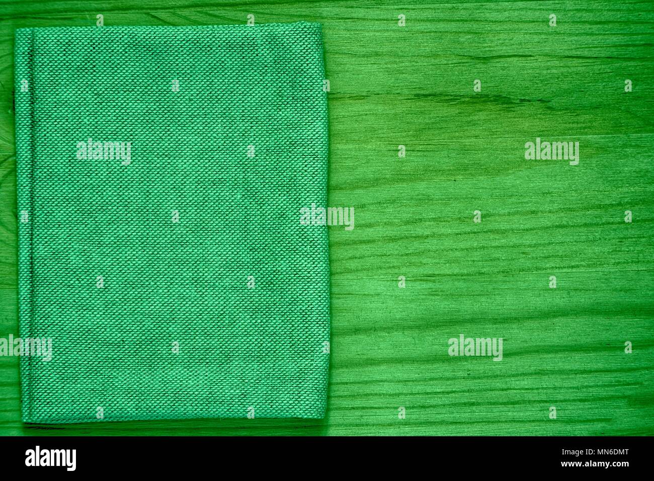 Ultra green Postcard sample, linen fabric surface on wooden table with free copyspace for greeting text, for mock-up or designer use, book cover sampl Stock Photo
