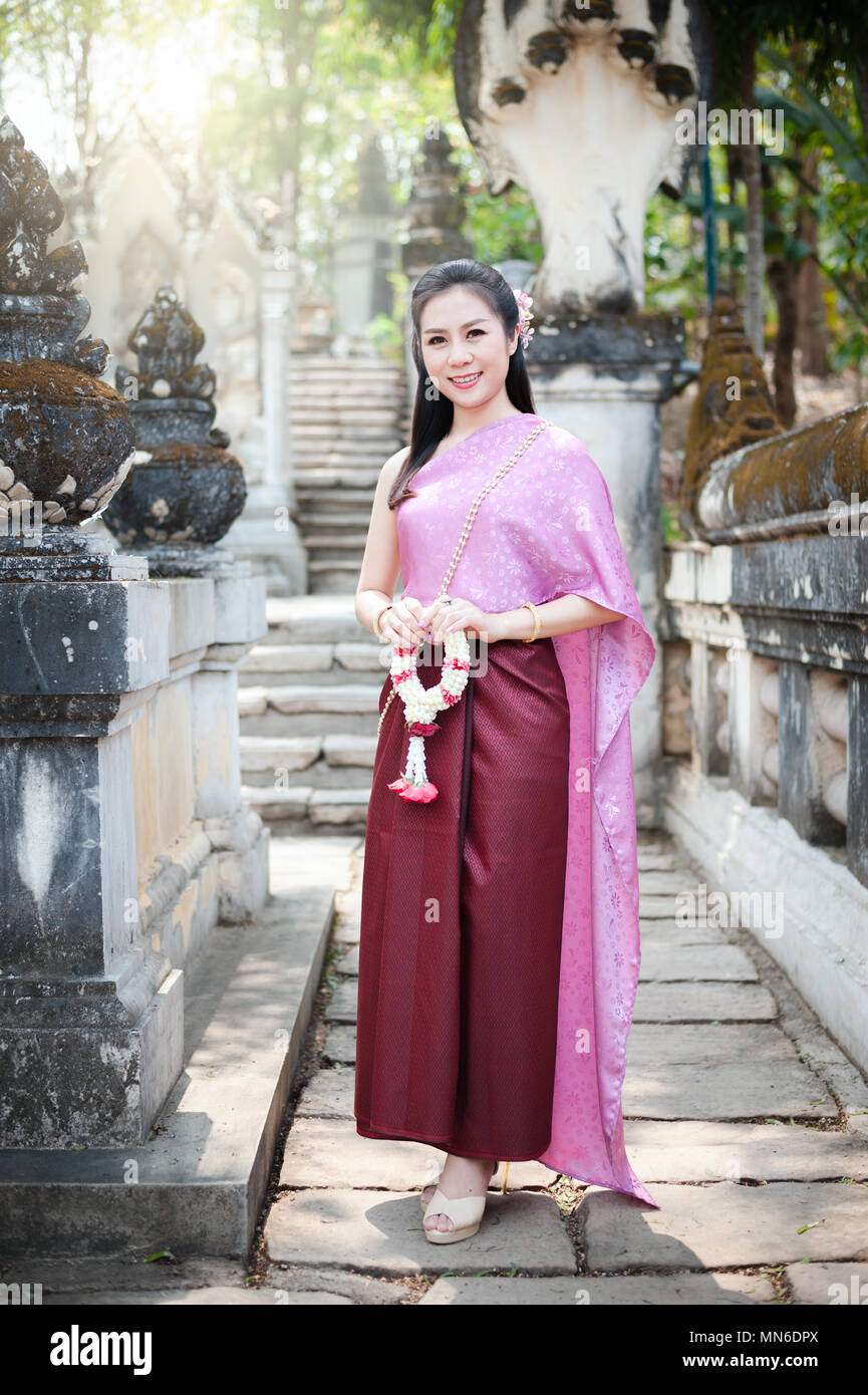 Portrait of beautiful Thai woman in Thai national dress standing at the  temple and hold white garland Stock Photo - Alamy