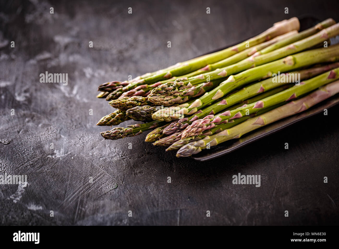 Fresh picked aspargus in horizontal format on black background Stock Photo