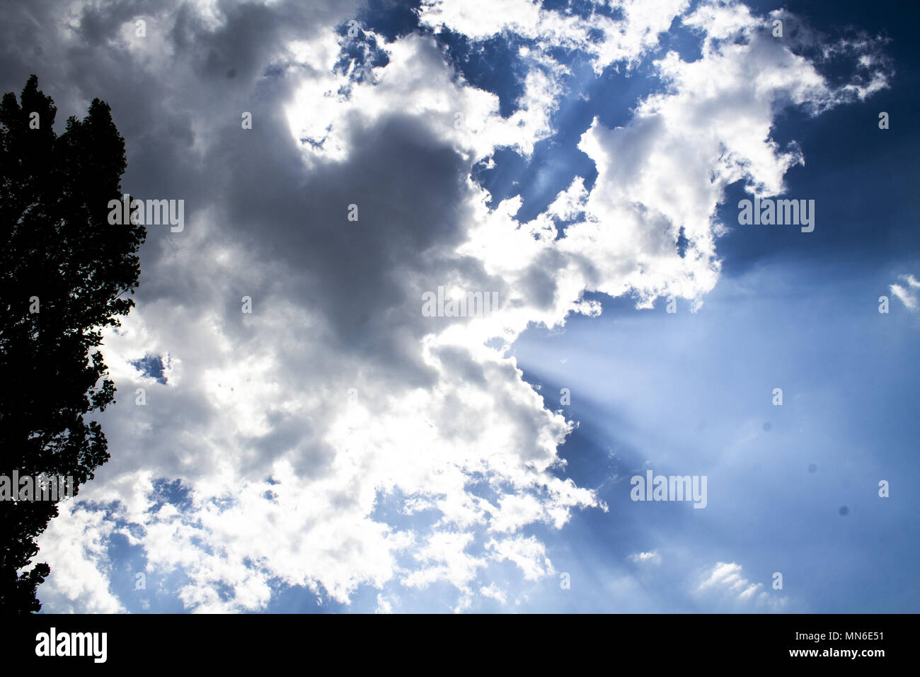 Rays of the sun coming out of the clouds blue sky Stock Photo