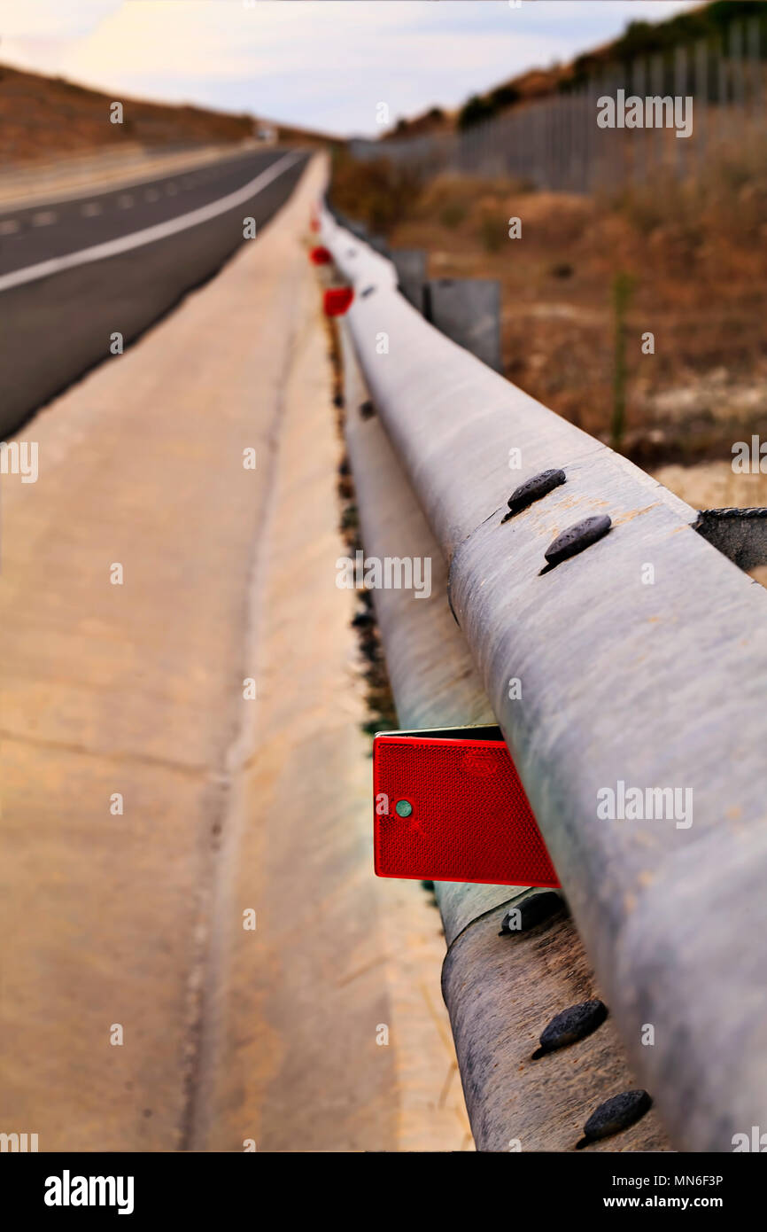 Steel guard rail barrier on the highway red reflective sign Stock Photo