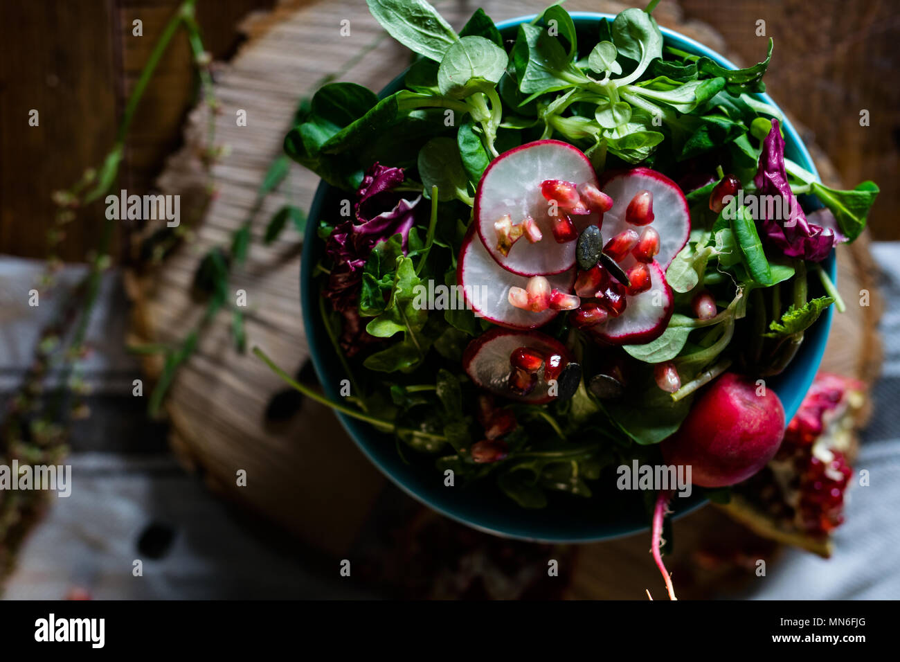 Rustic salad with leafy greens, radish and pomegranate Stock Photo Alamy